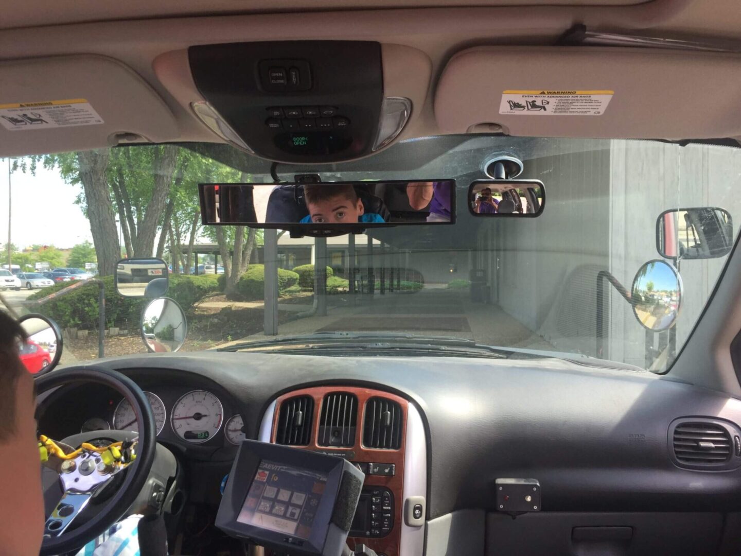 A person looking at the rearview mirror